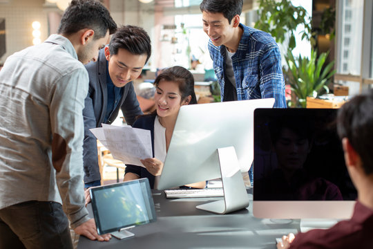 Young abroad students talking with teacher in computer lab