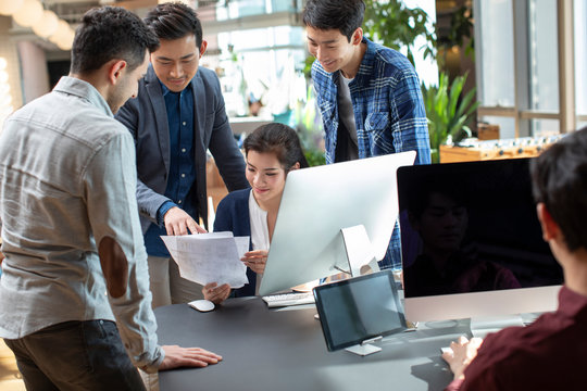 Young abroad students talking with teacher in computer lab