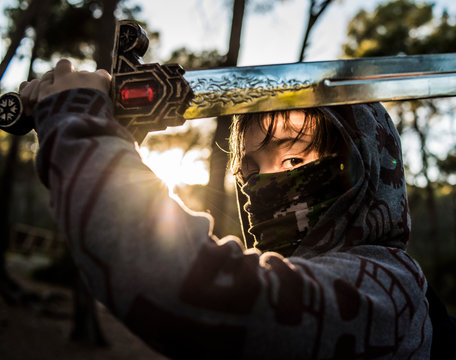 Child dressed as a warrior playing with his sword