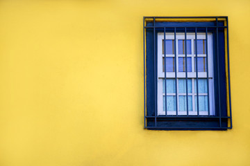 Fototapeta premium Colorful yellow house with blue shutters and window. In Porto, Portugal