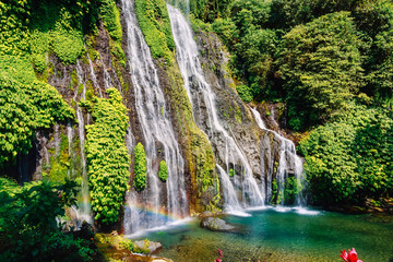 Fototapeta na wymiar Waterfall with blue crystal water and rainbow in tropical island