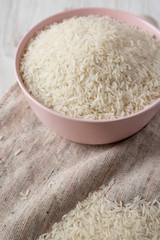Dry white rice basmati in a pink bowl, side view. Closeup.