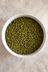 Raw green mung beans in a bowl, top view. Flat lay, overhead, from above. Close-up.