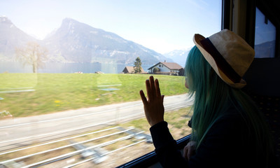 young hipster woman with hat as her green hair happy and relax with the train which a travel concept,Holiday vacation concept,vintage tone