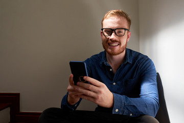 Red haired man with mobile phone