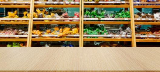 Department of baking in the supermarket. In the foreground is the top of a wooden table, counter.
