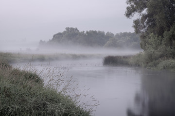 Fototapeta premium Fog at dusk on the river in the early morning