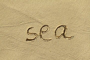 Fototapeta na wymiar Natural sand background with scrawled word ''Sea''