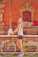 Fototapeta na wymiar Pretty woman standing with old bicycle outdoors.