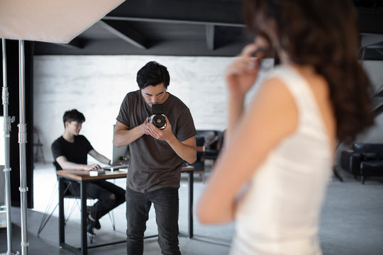 Photographer taking picture of model in studio