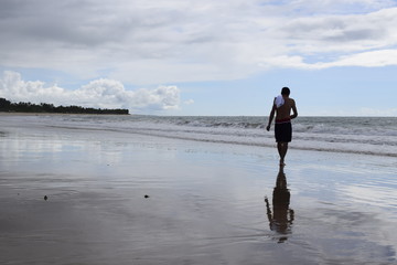 Homem caminhar na praia. Areia e horizonte de mar