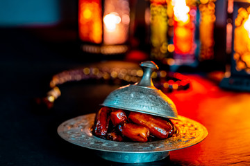 The Muslim feast of the holy month of Ramadan Kareem with dates on a tray on a dark background....