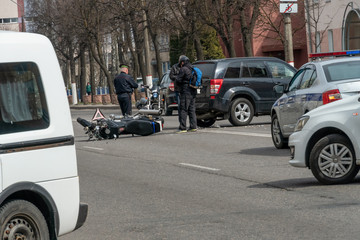 Accident in the city: a broken motorcycle and a car. Registration of a traffic accident. Traffic...