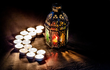 Ramadan Kareem with bright shining lantern and burning candles in the form of a month. The Muslim...
