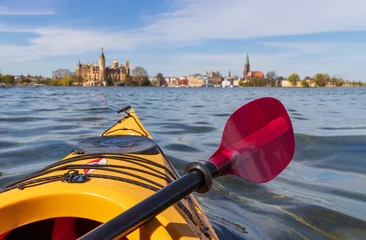 Foto op Canvas gelbes Paddelboot auf dem See, Schweriner Schloss im Hintergrund © tronixAS