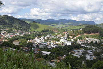 Fototapeta na wymiar Paisagem aérea de cidade entre montes verdes. Cidade de Nova Era em Minas Gerais.