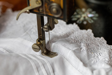 Process of sewing on the ancient sewing machine in the antiquarian case. Soft focus. 