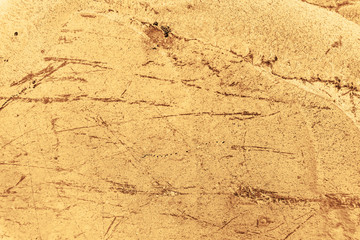 Vintage yellow background. Rough painted wall of aspen gold color. Imperfect plane of golden colored. Uneven old decorative toned backdrop of yellow tint. Texture of gold hue. Ornamental stony surface