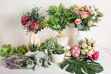 Various artificial flowers, bouquets in vases, succulents