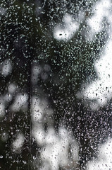 Rain drops on window glasses surface with bokeh background.