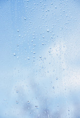 Rain drops on window glasses surface with bokeh background.