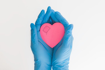 patch on the heart medicine, blue gloves, female hands, doctors save lives, concern for the health of the patient, pink heart, white background