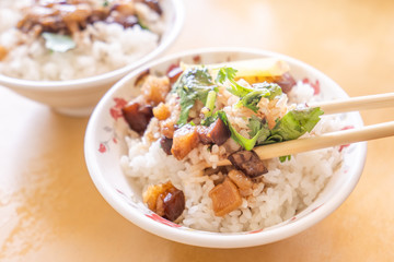 Braised pork over rice - Taiwan famous traditional street food delicacy. Soy-stewed pork on rice. Travel design concept. Top view,copy space,close up