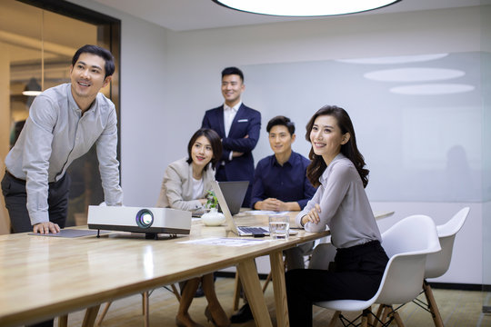 Business people looking at the slides  in board room