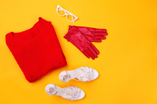 Top view of red swether, stylish shoes, red gloves and white glasses