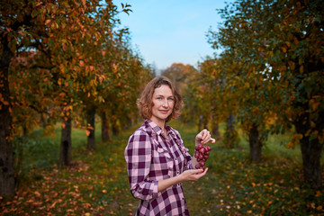 Cute woman with grapes in her hands in the garden
