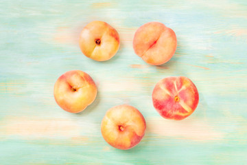Vibrant organic flat saturn peaches, shot from above on a teal background, forming a circular frame...