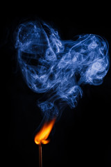 burning match with a heart on black background
