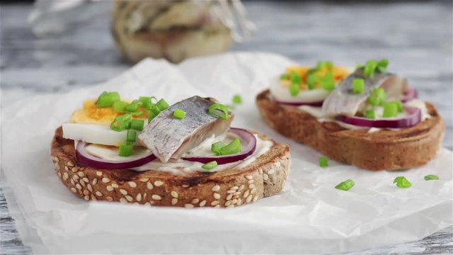 smorrebrod scandinavian open sandwich with rye bread herring boiling egg chopped green onions camera zoom