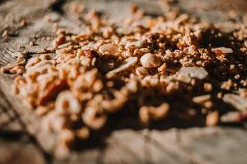 Close-up of cereals, muesli and nuts on a tree trunk. Sunlight