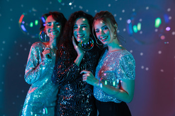 Happy Three beauty women wearing in shiny clothes - obrazy, fototapety, plakaty