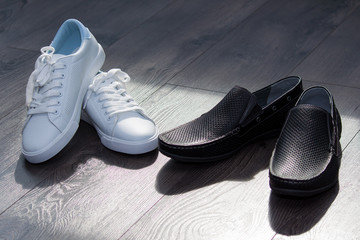 Couple of man black shoes and woman white sneakers. Fall in love, attention, watch concept.