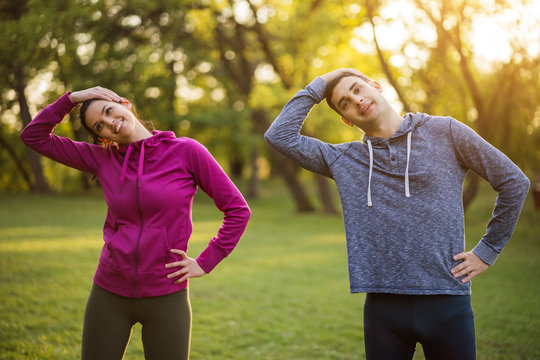 Happy couple is exercising in park.