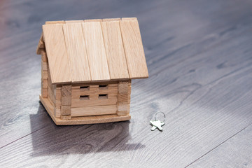 Fototapeta premium Closeup of wooden house model and silver keys on wooden background.
