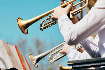A closeup of several trumpeters playing in a brass band
