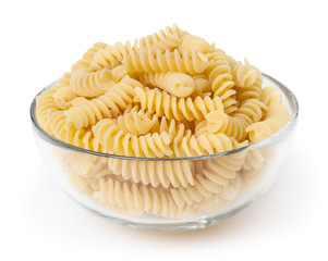 Uncooked fusilli pasta in glass bowl isolated on white background with clipping path