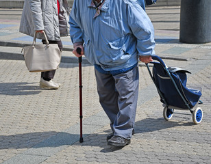 Old man with a wheeled shopping bag on the street
