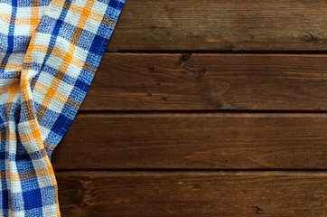 Obraz premium Blue checkered picnic cloth on brown wooden table.