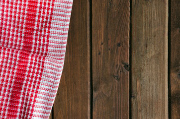 Red checkered picnic cloth on brown wooden table.