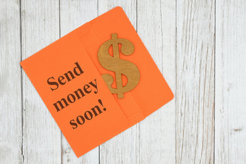Send money soon text with dollar sign symbol with orange envelope on textured wood desk