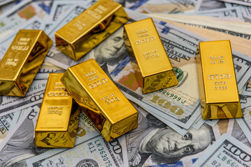 Gold bullion on american dollar banknotes close up