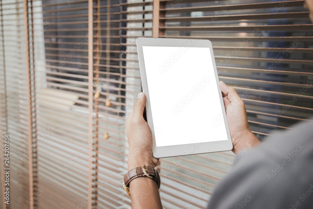 Wall mural mockup tablet on businessman hands empty display on home table with blur background. - image - image