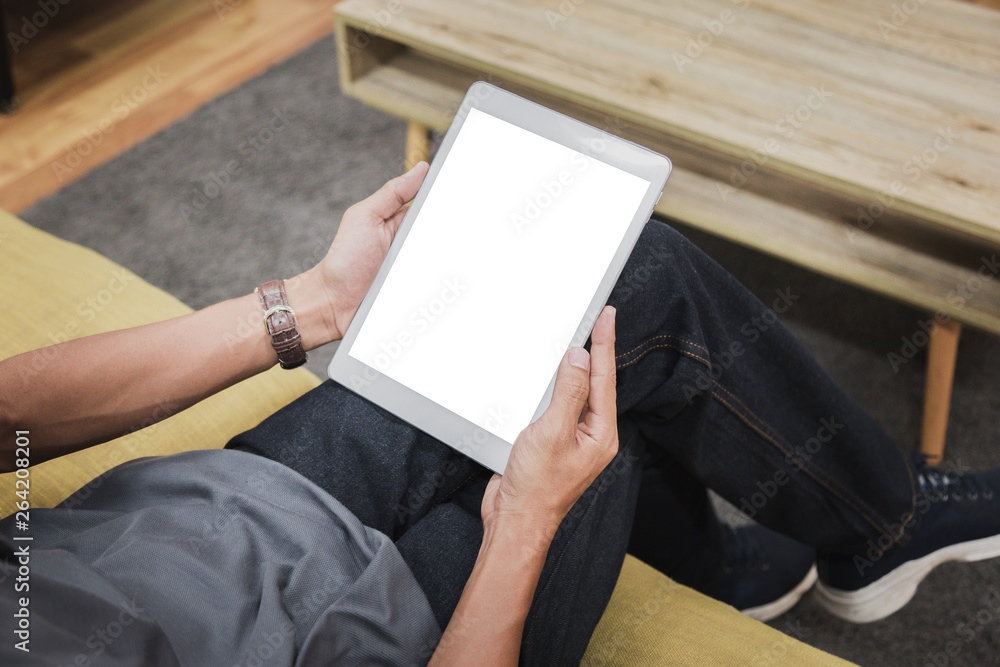 Wall mural mockup tablet on businessman hands empty display on home table with blur background. - image - image