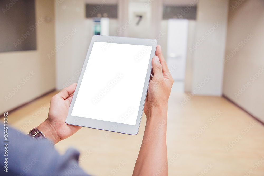 Wall mural mockup tablet on businessman hands empty display on home table with blur background. - image - image