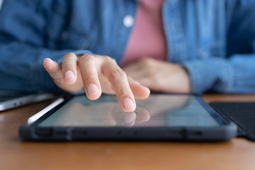   Closeup hand of asian women are using tablet on wood table