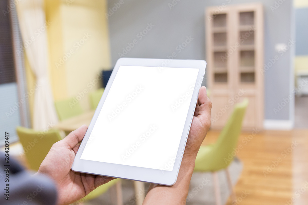 Wall mural mockup tablet on businessman hands empty display on home table with blur background. - image - image